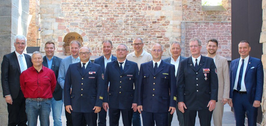 Eine Gruppe Männer steht auf der Bühne der Stiftsruine in Bad Hersfeld. Vier von ihnen tragen eine Feuerwehr-Uniform. Sie lächeln.