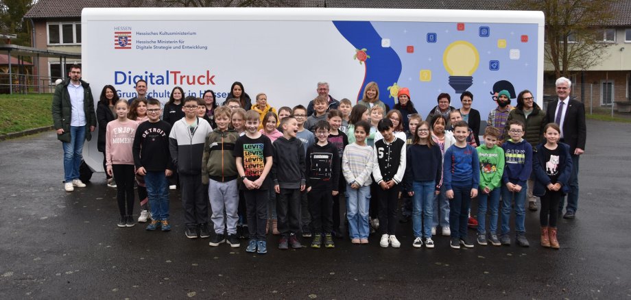 Schülerinnen und Schüler der Kreuzbergschule in Philippsthal stehen mit Vertretern aus Politik und Bildungssektor vor dem Digital-Truck des Landes Hessen.