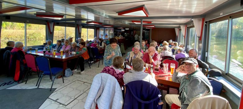 Auch im Innenraum des Schiffes sitzen viele ältere Menschen an Tischen. Sie sind gut gelaunt.