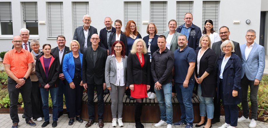 Mehrere Menschen stehen im Innenhof des Landratsamtes. Sie schauen in die Kamera und lächeln.