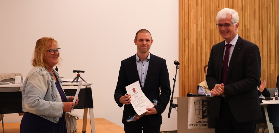 Dr. Martin Schörner wird von der Vorsitzenden Petra Wiesenberg während der Kreistagssitzung vereidigt, während Landrat Torsten Warnecke ihm gratuliert.